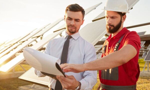 Contractor and manager working in field with solar panels