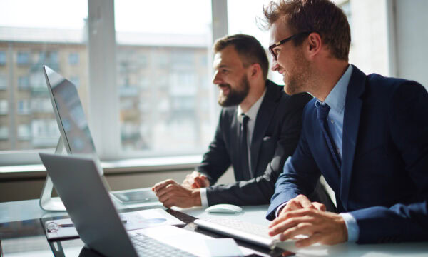 Businessman and his colleague looking at computer monitor