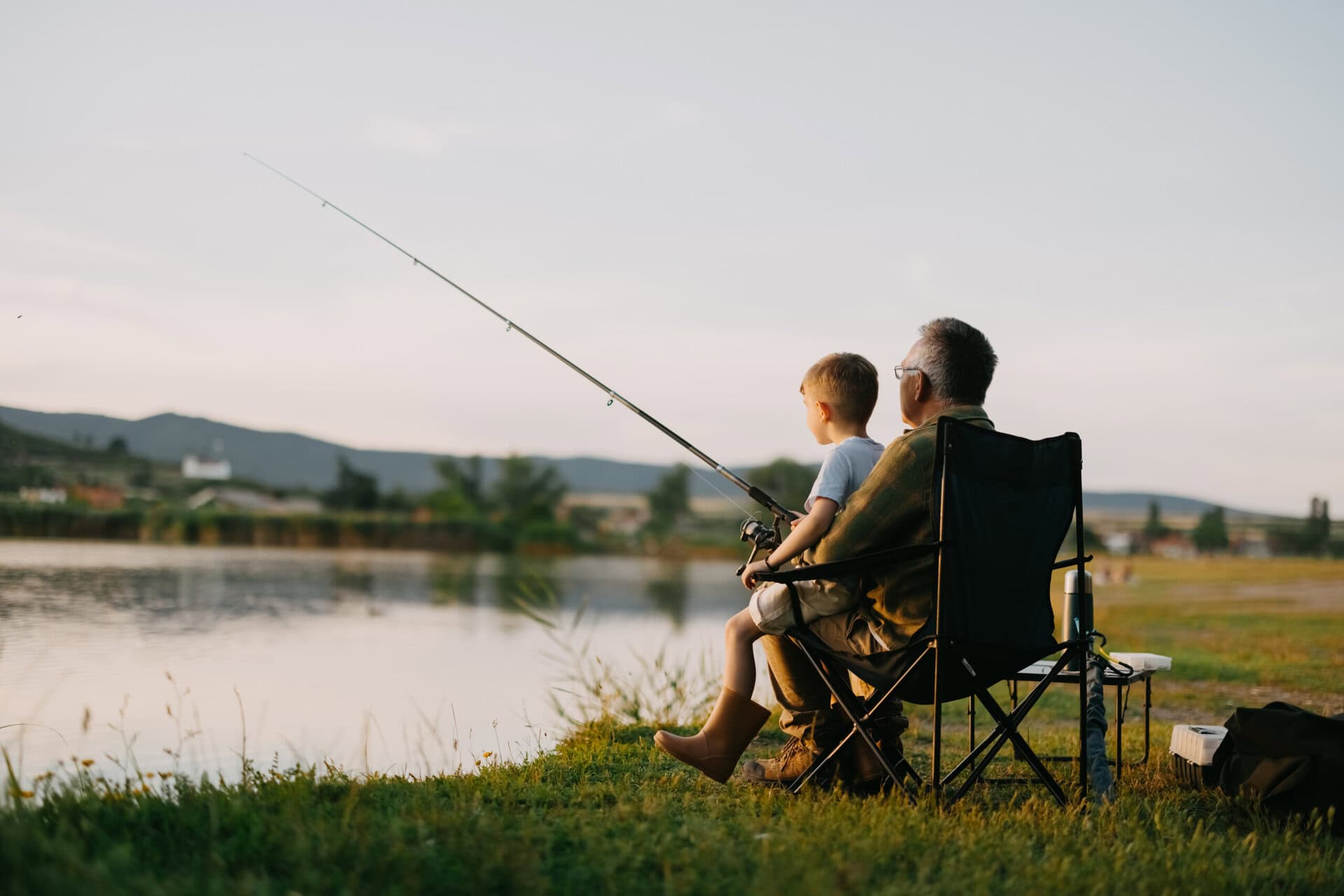 grandfather teaches grandson to fish